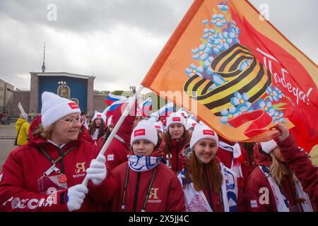 Mosca, Russia. 9 maggio 2024. Le persone tengono bandiere durante una sfilata festosa in occasione della giornata della Vittoria durante la fiera internazionale e il forum della Russia Expo presso il centro espositivo VDNKh di Mosca, Russia. La Russia celebra 79 anni dalla vittoria sulla Germania nazista nella seconda guerra mondiale Foto Stock