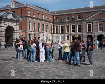 Una guida turistica che mostra le persone intorno al cortile del castello di Dublino nella città di Dublino, Irlanda. Foto Stock