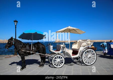 Chania, Creta, Grecia. Carrozza nera e buggy bianca sul lungomare Foto Stock