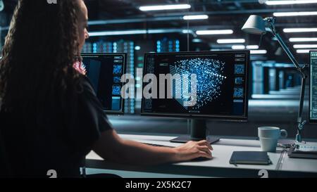 International Female computer Scientist sviluppa Neural Network presso Her Workstation. Sul display viene visualizzata la proiezione grafica della rete neurale, simulazione dell'intelligenza artificiale Foto Stock