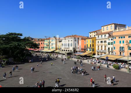 Verona, Italia. Strada pedonale acciottolata con colorati edifici caffe' e gente conduce all'Arena Foto Stock