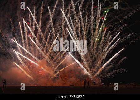 I vivaci fuochi d'artificio illuminano il cielo notturno del deserto Foto Stock