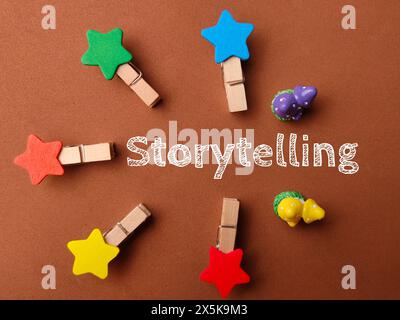 Vista dall'alto clip in legno con testo Storytelling su sfondo marrone. Foto Stock
