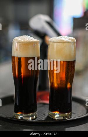 birre con tappo nero sul vassoio con sfondo sfocato. Foto Stock