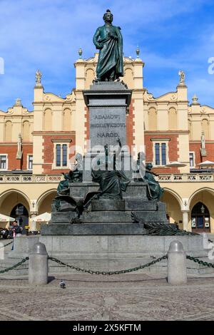 Polonia, Cracovia, Piazza del mercato. Statua di Adam Bernard Mickiewicz, poeta nazionale polacco, drammaturgo, saggista, pubblicista, traduttore, professore. Panno Hall sullo sfondo. Foto Stock