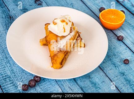 Pancake crepe suzette con arancia e gelato su un piatto bianco. Primo piano. Messa a fuoco selezionata. Foto di alta qualità Foto Stock