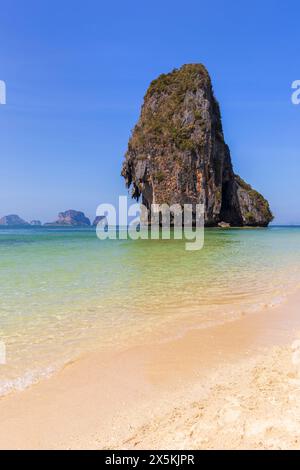 Splendido paesaggio di un'alta scogliera calcarea, cielo blu e mare turchese presso la spiaggia di Phranang (Phra Nang) a Railay, Krabi, Thailandia, in una giornata di sole. Foto Stock