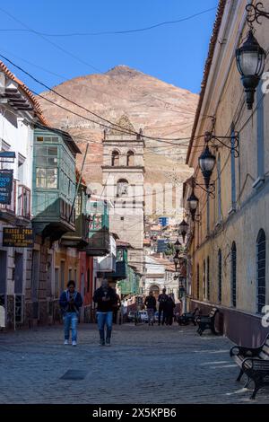 Potosi, una stradina stretta con un campanile e vista sul Cerro Rico, la grande vetta conica e centro del boom delle miniere d'argento. Foto Stock