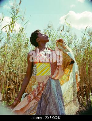 USA, New York, giovane donna alla moda in campo erboso Foto Stock