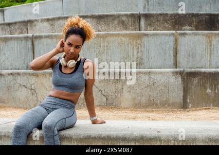 Sporty giovane donna seduta sui gradini Foto Stock