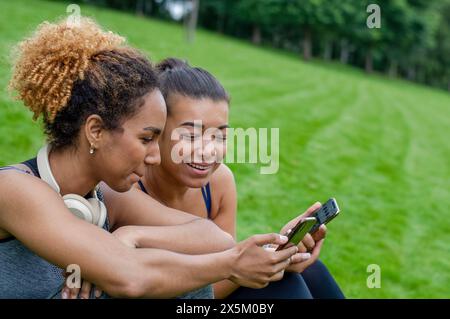 Amici donne che usano i telefoni Foto Stock