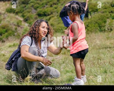 Madre con la figlia che raccoglie l'erba Foto Stock