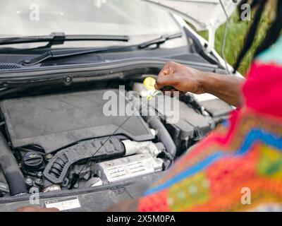 Uomo che controlla il livello dell'olio dell'auto Foto Stock