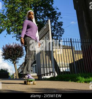 Regno Unito, Londra, giovane donna che indossa lo skateboard hijab in città Foto Stock