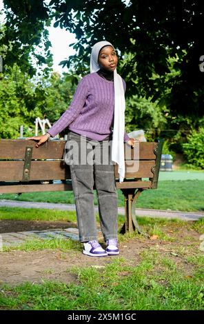 Regno Unito, Londra, Ritratto di giovane donna che indossa hijab in piedi nel parco Foto Stock