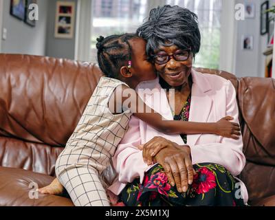 Bisnipote che bacia bisnonna sulla guancia Foto Stock