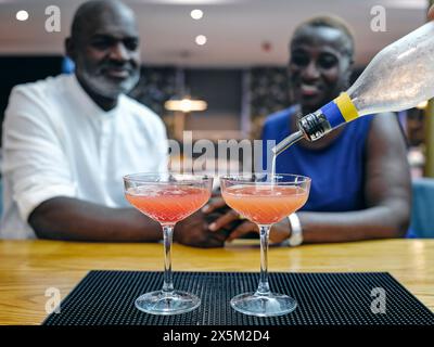 Regno Unito, coppia matura che si gusta un cocktail al bancone del bar Foto Stock