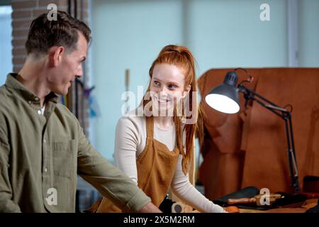 i giovani entusiasti e felici si divertono a lavorare insieme sul posto di lavoro, un bell'uomo flirtando con una bella donna, la simpatia Foto Stock