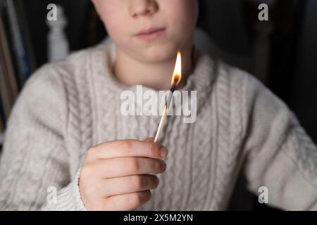 Fiammifero acceso per bambini, educazione alla sicurezza antincendio, tempo di gioco sorvegliato, guida dei genitori, curiosità infantile, attività didattiche Foto Stock