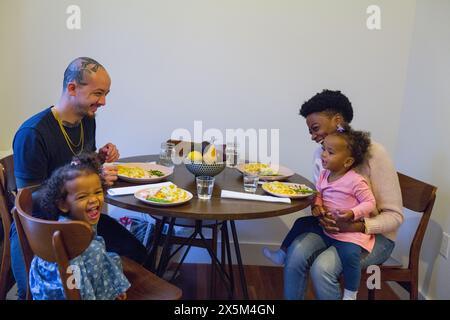 Famiglia con figlie che pranzano a tavola Foto Stock