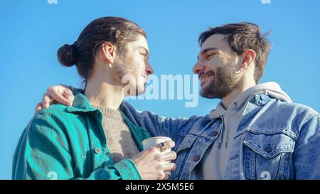 Coppia gay sorridente che abbraccia all'aperto Foto Stock