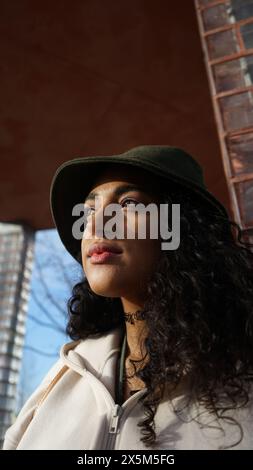 Primo piano di una donna pensiva in cappello all'aperto Foto Stock