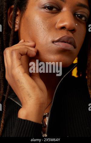 Primo piano di una donna con dreadlock e anello per il naso Foto Stock