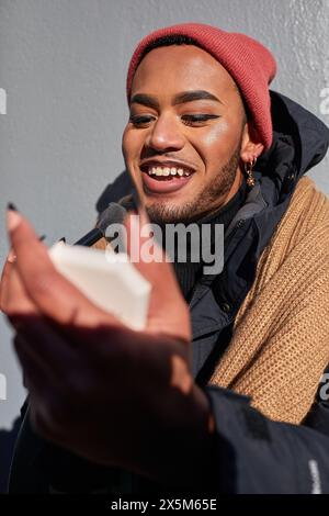 USA, New York City, un queer sorridente che fa domanda di trucco Foto Stock