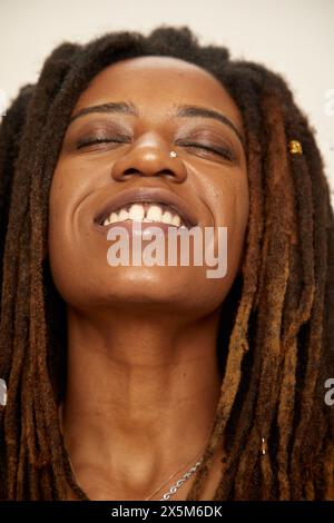 Primo piano di una donna sorridente con dreadlock Foto Stock