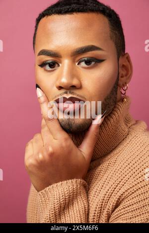 Ritratto in studio di un uomo queer su sfondo viola Foto Stock
