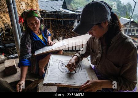 Una donna Flower Hmong disegna un modello per il suo ricamo tradizionale, Mu Cang Chai, Yen Bai, Vietnam Foto Stock