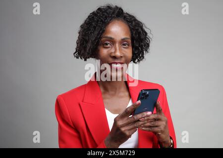 Ritratto di una donna d'affari sorridente che usa lo smartphone Foto Stock