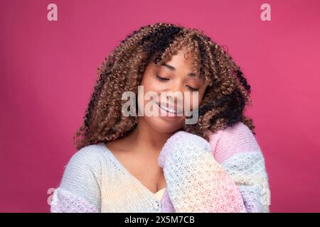 Donna sorridente in maglione colorato Foto Stock