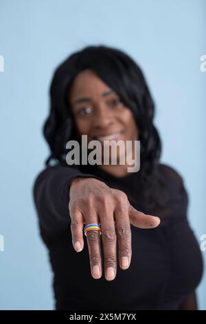 Ritratto in studio di una donna matura che mostra un anello multicolore Foto Stock