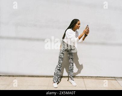 Giovane donna utilizza lo smartphone Foto Stock