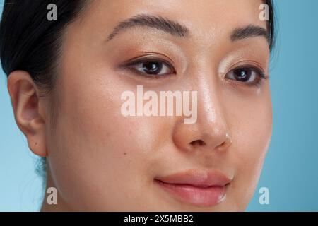 Primo piano del volto di una donna su sfondo blu Foto Stock