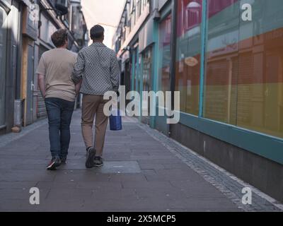 Regno Unito, South Yorkshire, Vista posteriore della coppia gay che cammina in città Foto Stock