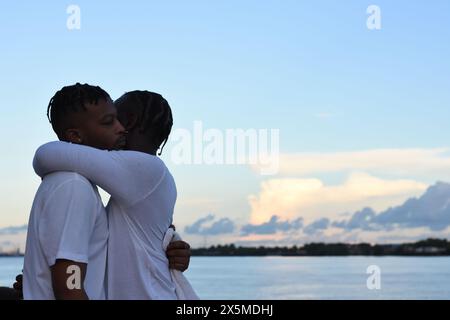 USA, Louisiana, coppia gay che abbraccia contro il cielo Foto Stock