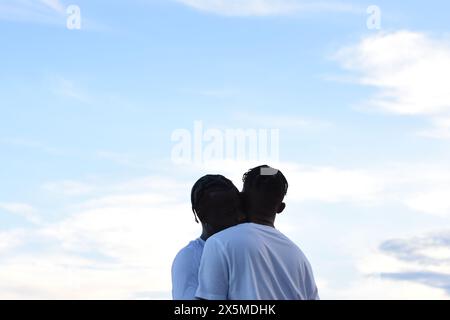 USA, Louisiana, coppia gay che abbraccia contro il cielo Foto Stock