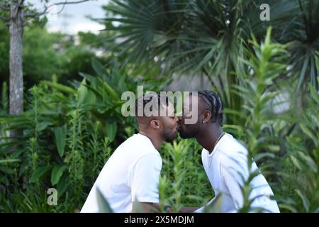 USA, Louisiana, coppie gay che si baciano in un parco con piante tropicali Foto Stock