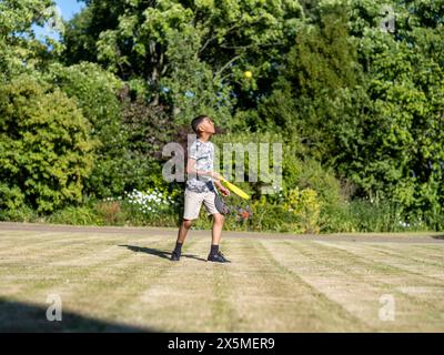 Ragazzo (10-11) che gioca a paddle ball Foto Stock