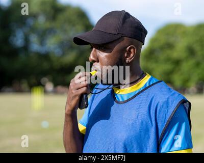 Allenati con fischio sul campo da calcio Foto Stock