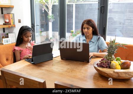 Regno Unito, Londra, madre e figlia che utilizzano i computer portatili a casa Foto Stock
