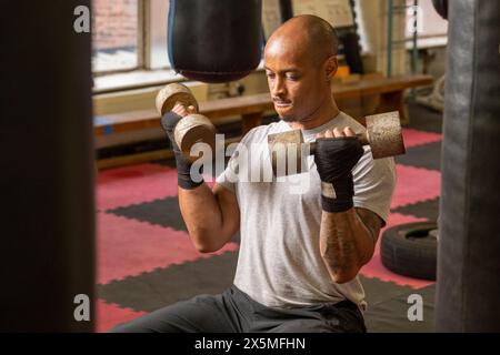 Uomo maturo che solleva manubri in palestra Foto Stock