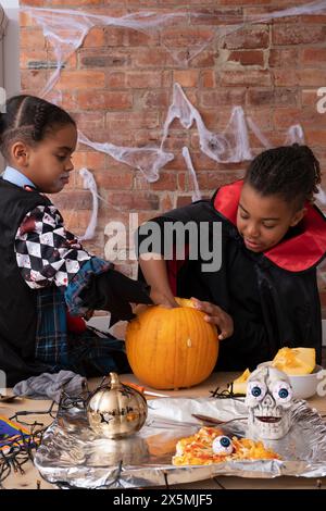 Bambini in costumi di Halloween che fanno Jack OLantern Foto Stock