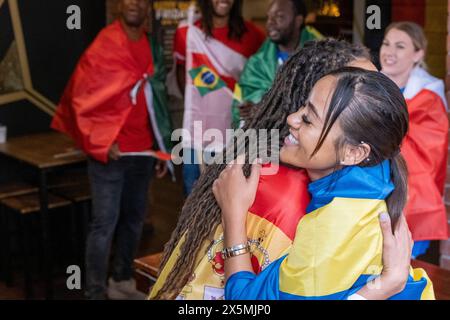 Amici vestiti con bandiere nazionali che celebrano la competizione di coppa del mondo Foto Stock