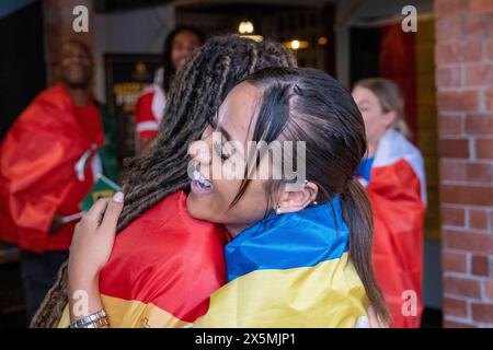 Amici vestiti con bandiere nazionali che celebrano la competizione di coppa del mondo Foto Stock