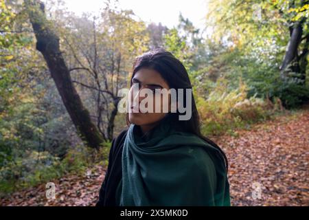 Ritratto di donna in piedi sul sentiero nella foresta Foto Stock