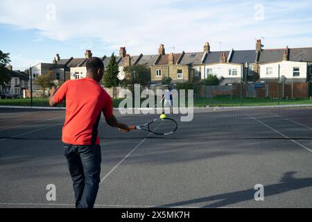 Gente che gioca a tennis sul campo di quartiere Foto Stock
