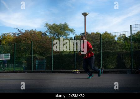 Uomo che gioca a tennis sul campo di quartiere Foto Stock